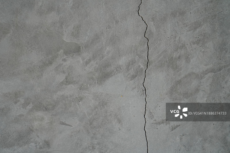 水泥墙上的裂缝，裸露的抛光灰色和光滑的表面纹理混凝土材料复古背景细节建筑施工砖墙抹灰和油漆图片素材