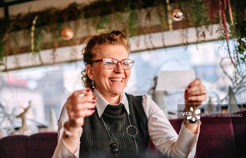 女子发现自己手中有中奖彩票，面露惊喜之色。图片素材