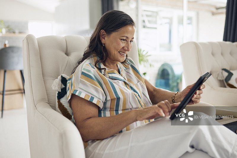 中年妇女在家使用平板电脑图片素材