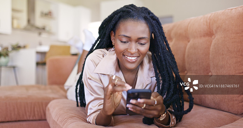 在家中使用智能手机的优雅黑人女性图片素材