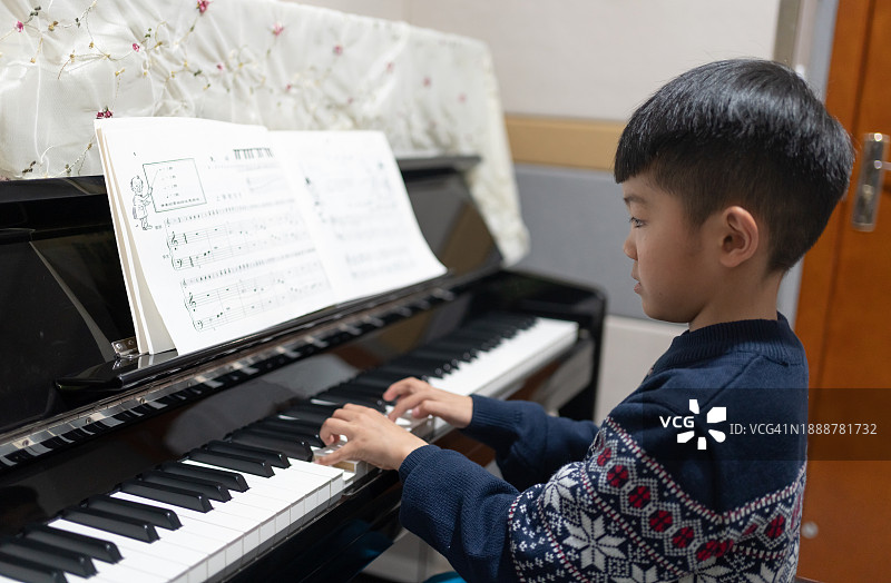 在钢琴房练习的亚洲男孩图片素材