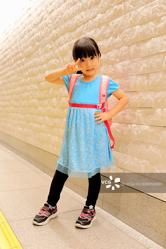 比耶手势的可爱小女孩全身照，看向镜头图片素材