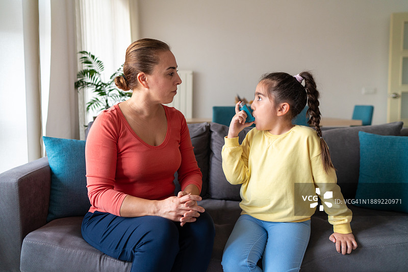 小女孩和母亲在家，使用吸入器图片素材