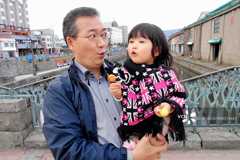 父子快乐相伴，父亲抱着孩子，两人都心情愉快图片素材