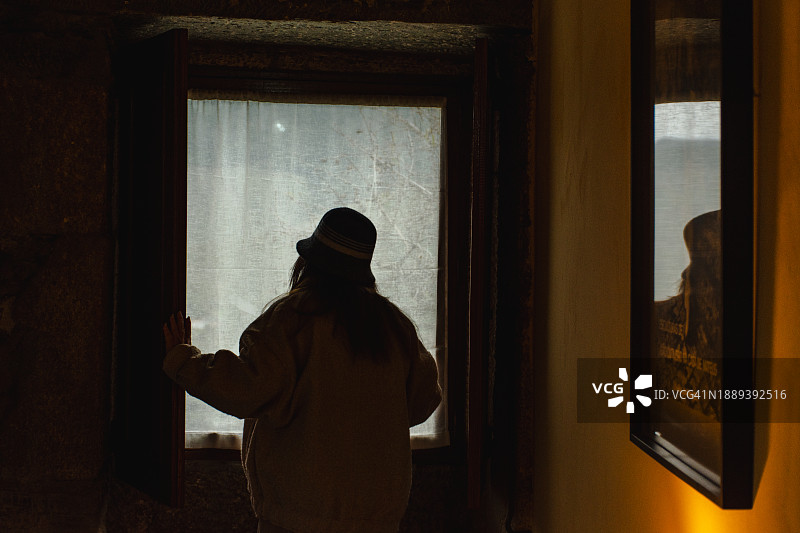 女人在窗边观赏斗罗河风光图片素材