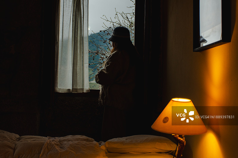 女人在窗边观赏斗罗河风光图片素材