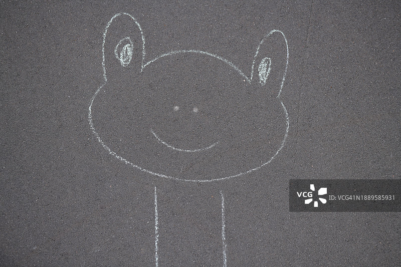 儿童在沥青上用粉笔画的青蛙图片素材