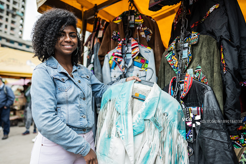 街头市场里看衣服的年轻女人肖像图片素材