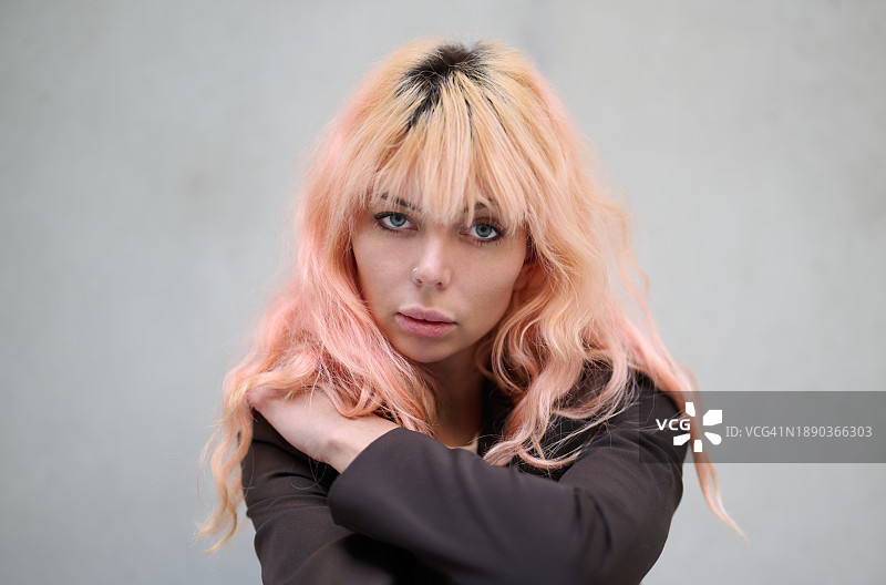 靠墙站立的红发年轻女子肖像图片素材