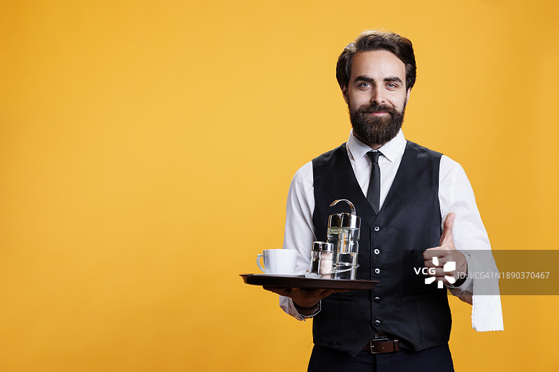 站在黑色背景前手持托盘的服务员肖像图片素材