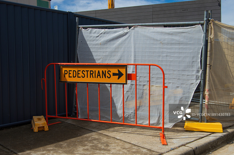 施工标志旁移动围栏上写有“行人”字样的标志牌图片素材