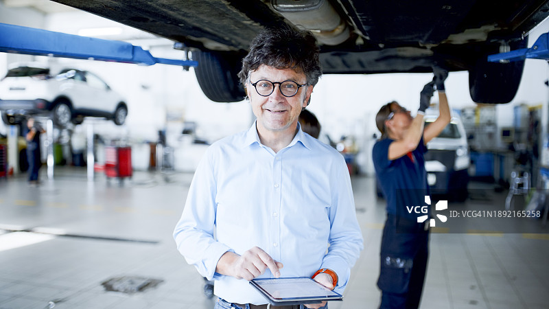 经理与女机械师在汽车修理厂工作肖像图片素材