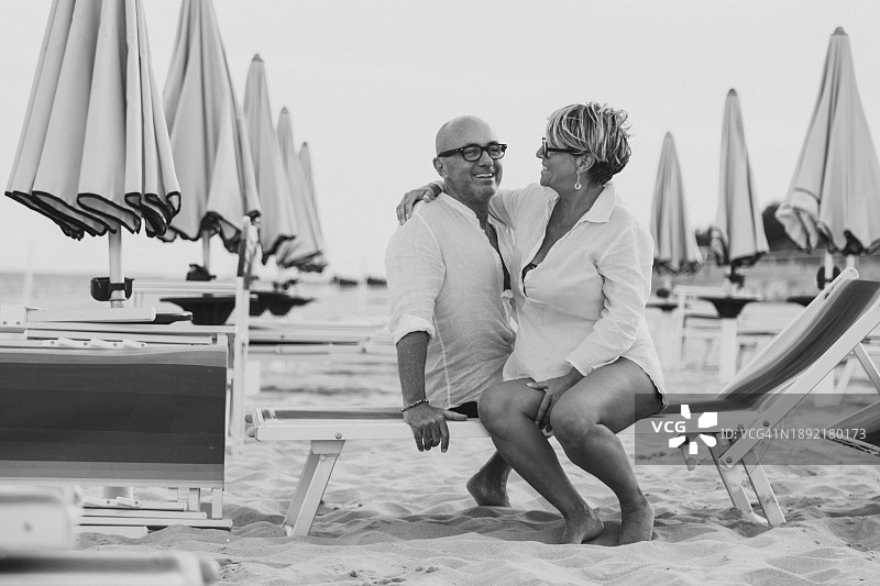 情侣在沙滩躺椅上放松身心，享受乐趣图片素材