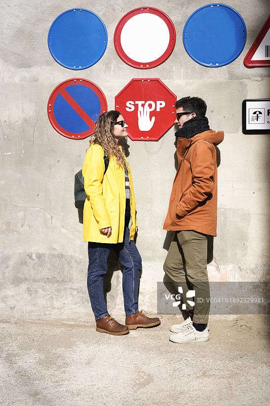 彩色交通标志旁的对峙情侣图片素材