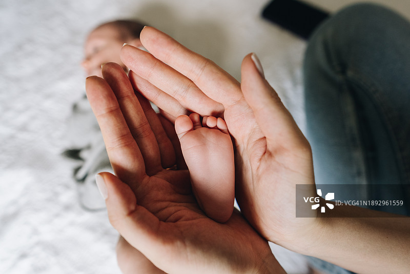 母亲在家抱着新生儿的脚图片素材