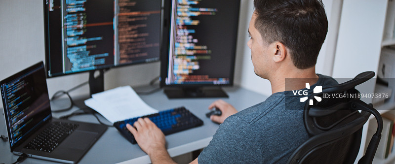 美国男性软件工程师在家用笔记本电脑工作，进行应用程序编码，自由职业图片素材