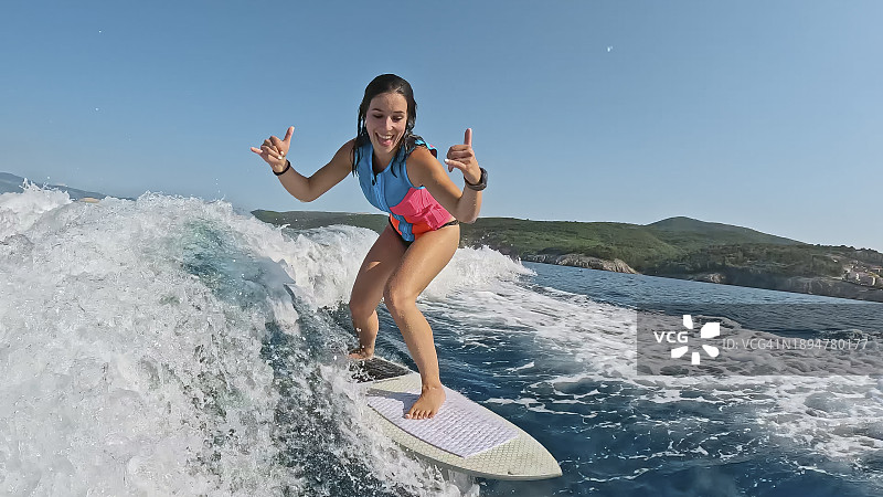 女子在海上享受尾波冲浪，在清凉的海浪中体验纯粹的刺激与快乐图片素材