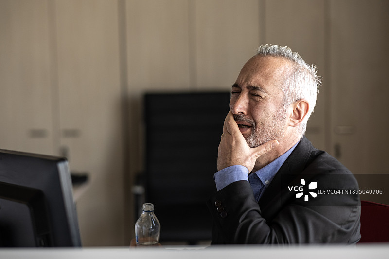 办公室里牙痛的白发商人图片素材