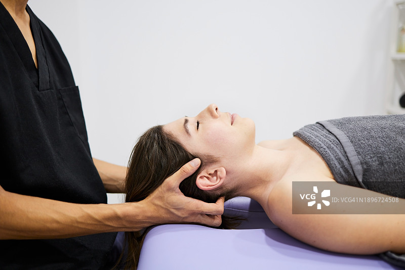 脊椎指压治疗师按摩患者头部图片素材