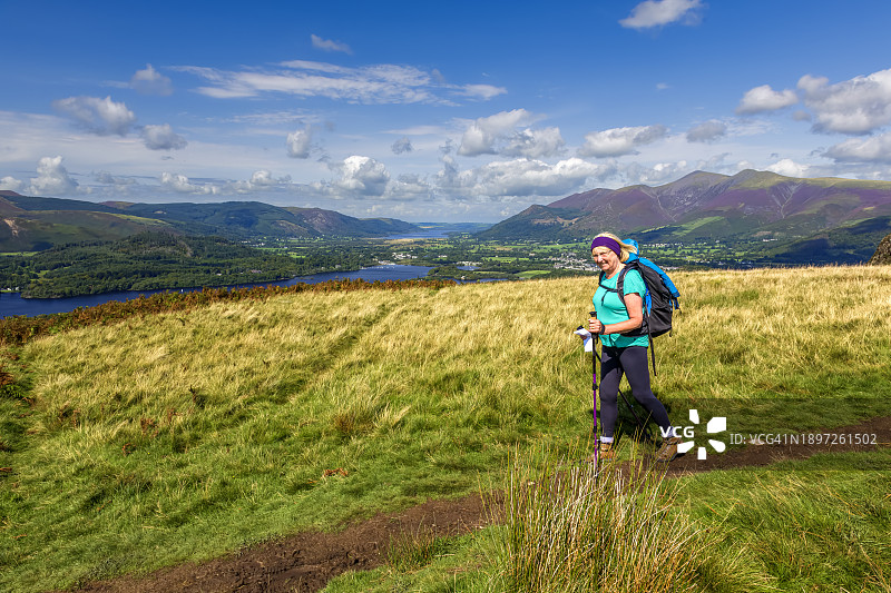 年长的女人在英国坎布里亚郡湖区 Walla Crag 徒步旅行，使用登山杖图片素材
