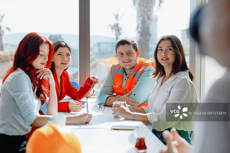 积极的办公室会议：经理和创意团队在现代明亮的工作室会议室中开会图片素材