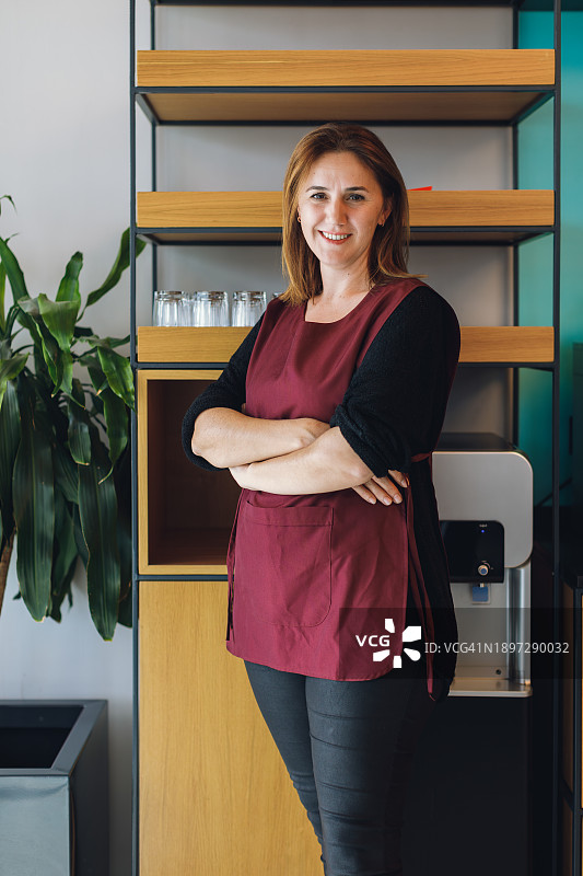 咖啡店里的快乐店主：微笑的女商人肖像图片素材