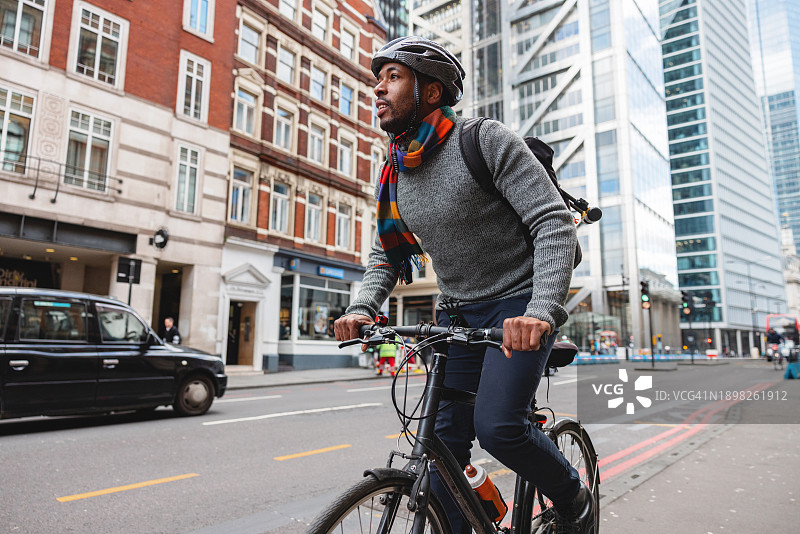 有环保意识的黑人男子早上骑自行车上班图片素材