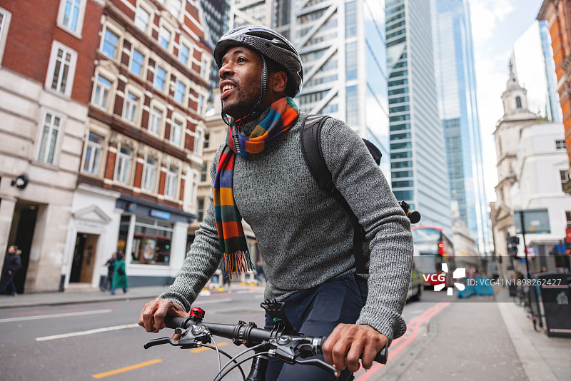 有环保意识的黑人男性在下班后骑自行车图片素材