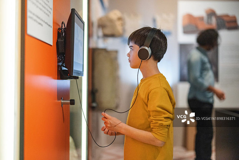 在历史博物馆里听讲解的白人小男孩图片素材