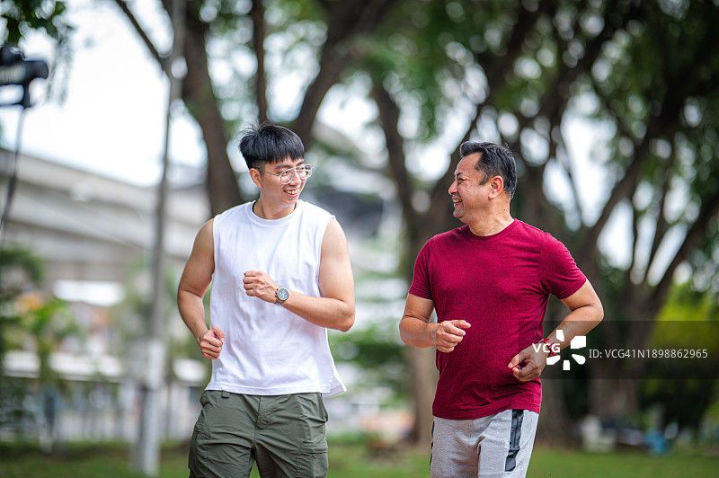 健身激励：教练激励中年男人在公园锻炼图片素材