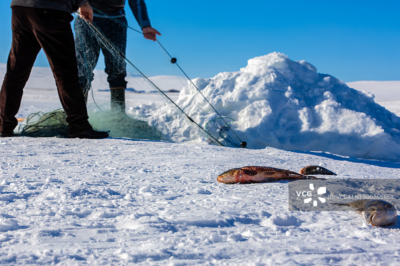 冰上钓鱼探险：冰封湖面钻孔图片素材