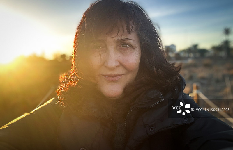 日落时分的中年妇女自拍图片素材