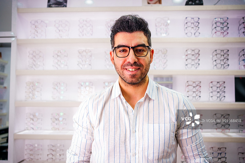 面带微笑的年轻人试戴眼镜图片素材