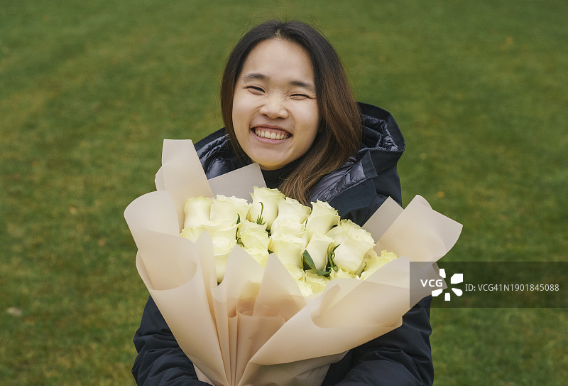 求婚后，在公园拿着新娘捧花的年轻女子图片素材