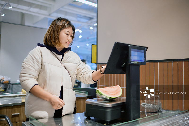亚洲女士在超市称西瓜图片素材