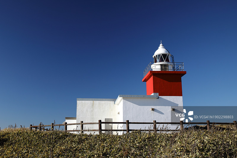 蓝天下，草山上的红色灯塔图片素材