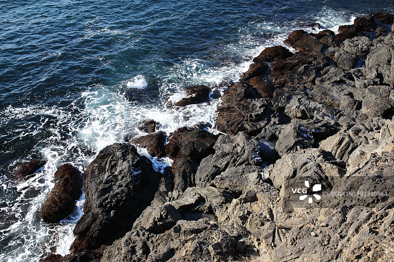 海浪冲击火山岩和放射状玄武岩柱图片素材