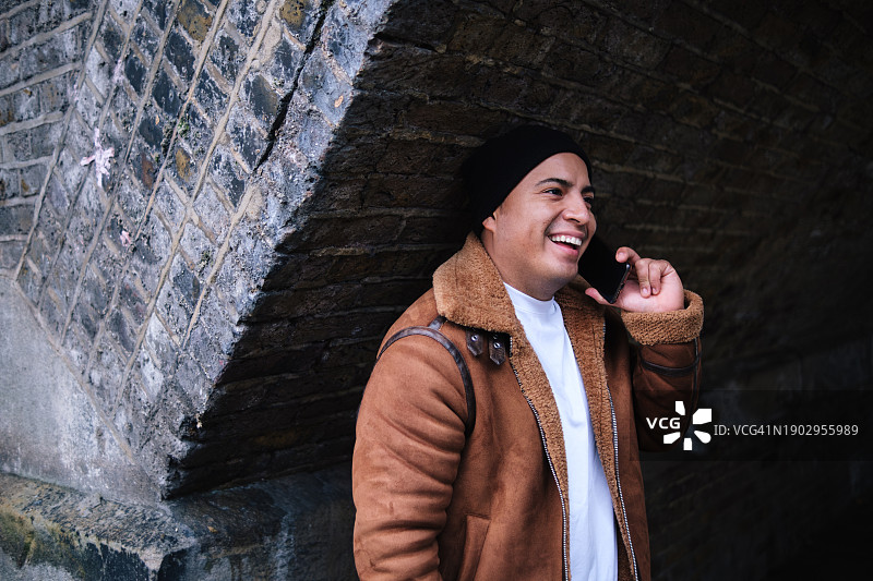 男人在桥拱下打电话大笑图片素材