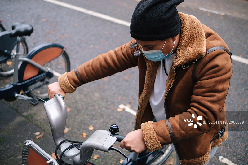 在城市共享单车站戴口罩的男人图片素材
