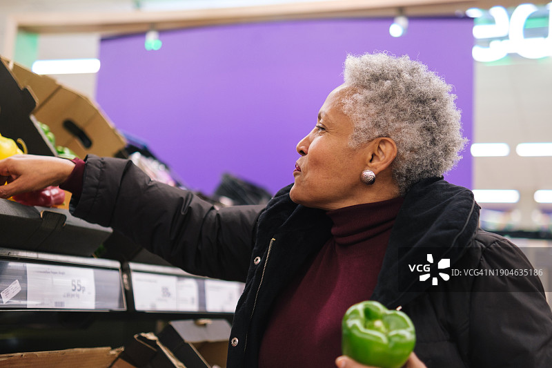 在超市挑选蔬菜的年长女人图片素材
