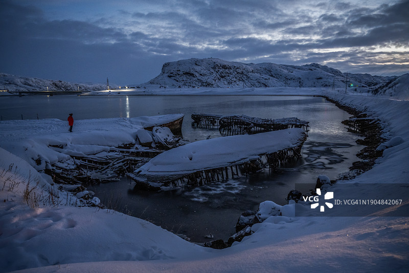 日出时分巴伦支海沿岸的旧船木制部件，船舶墓地，俄罗斯摩尔曼斯克州捷里别尔卡图片素材
