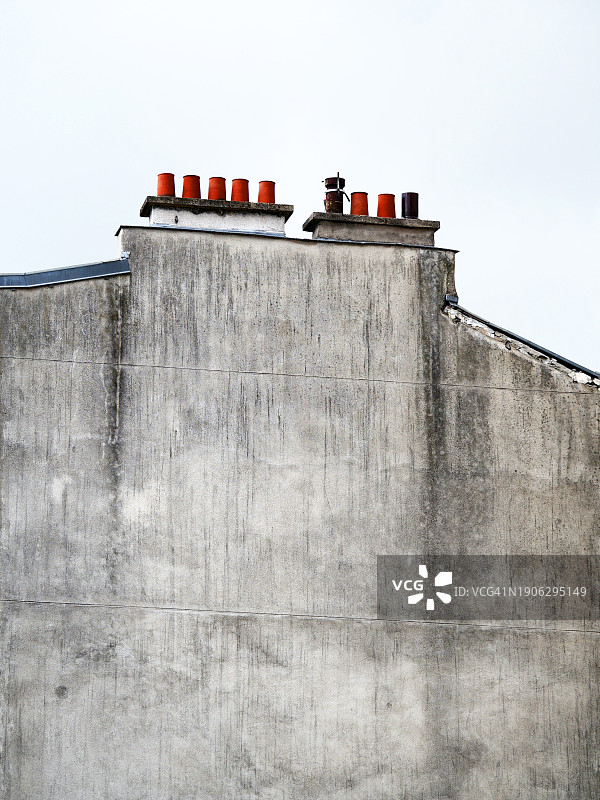特写：巴黎住宅楼带有烟囱的风化灰色混凝土山墙图片素材