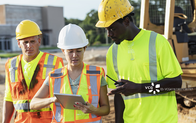 三名建筑工人正在看平板电脑图片素材