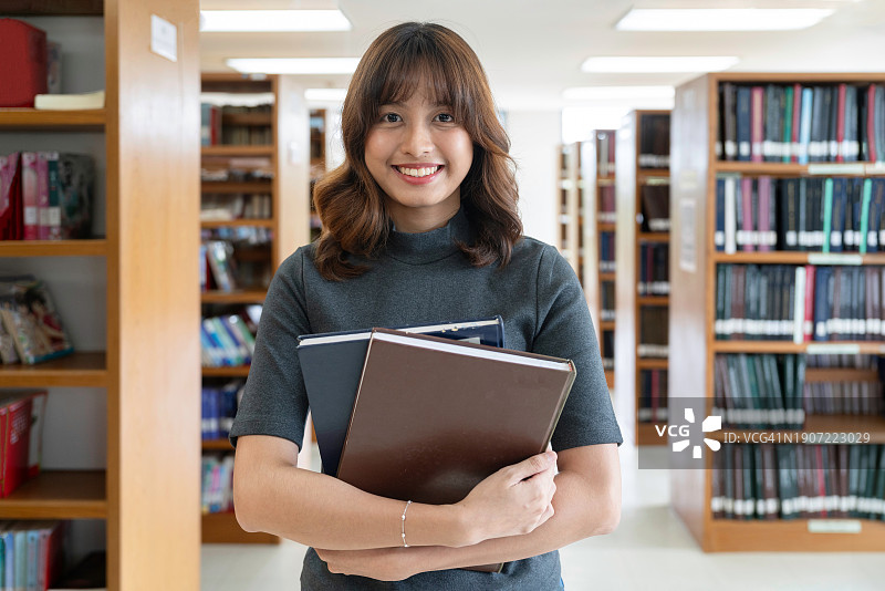 学习和教育理念：重返校园，知识进阶，大学生在图书馆开心微笑图片素材