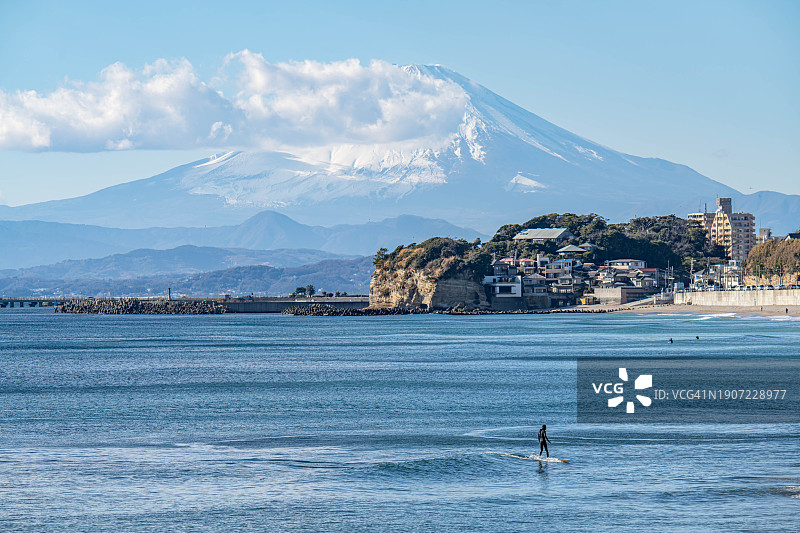 日本神奈川县阳光明媚的海滩和富士山雪景图片素材