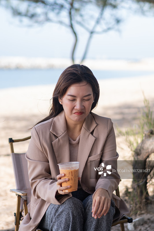 年轻女商人于咖啡馆放松并用吸管饮用冷饮缓解牙齿不适图片素材