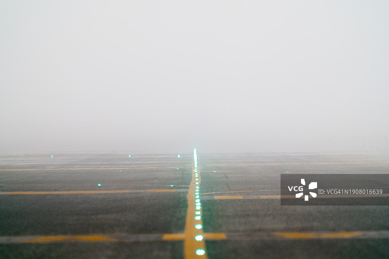 消失在机场雾中的跑道灯光，能见度降低图片素材