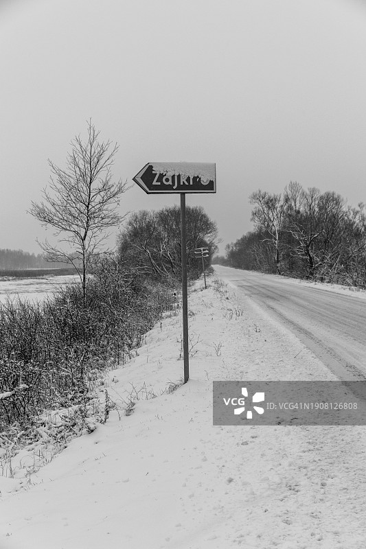 被冰雪覆盖的通往扎伊基村庄的道路标志，位于波德拉谢省别布扎国家公园图片素材