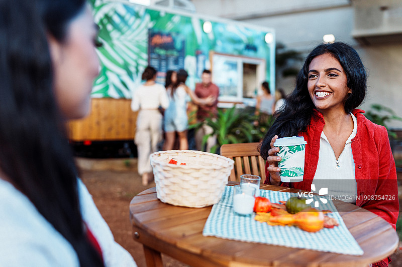年轻女人坐在室外手持咖啡图片素材