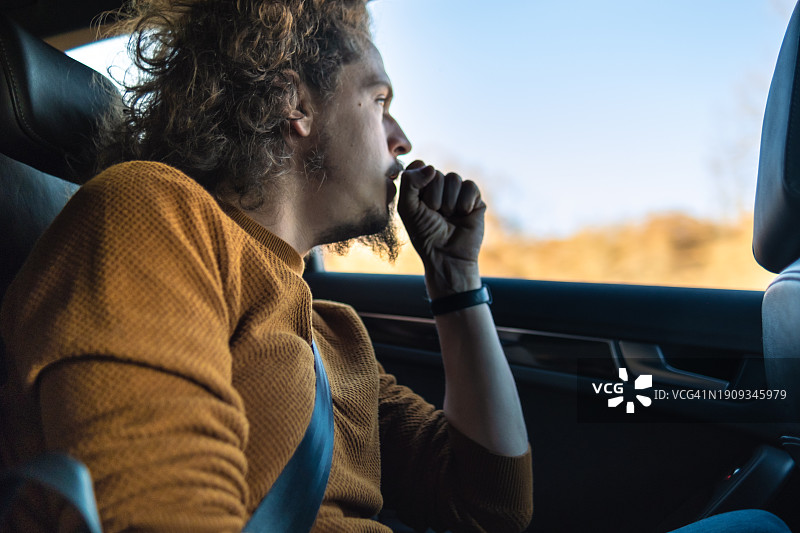 年轻男人在后座向窗外看图片素材